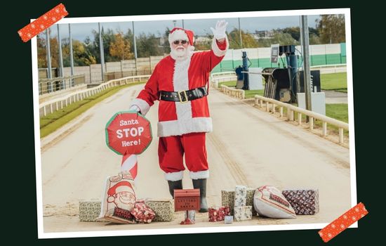 Image shows Santa Claus waving to camera while standing on the track at Limerick Greyhound Stadium with Christmas gifts